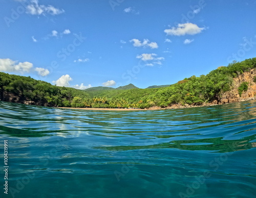 Petite anse in Pointe noire, idyllic beach in Basse Terre, guadeloupe. Caribbean island with mountains and tropical beach seen from the sea