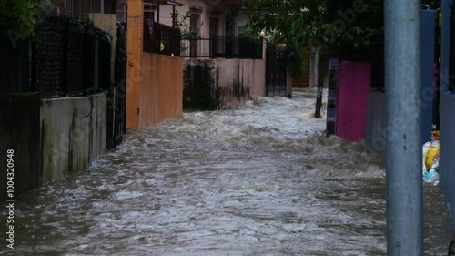 Alleyway and buildings flooded with heavy rainfall water, wide angle shot of flood water flowing in a alleyway between flooded buildings in Kathmandu, Nepal during September monsoon 2024.