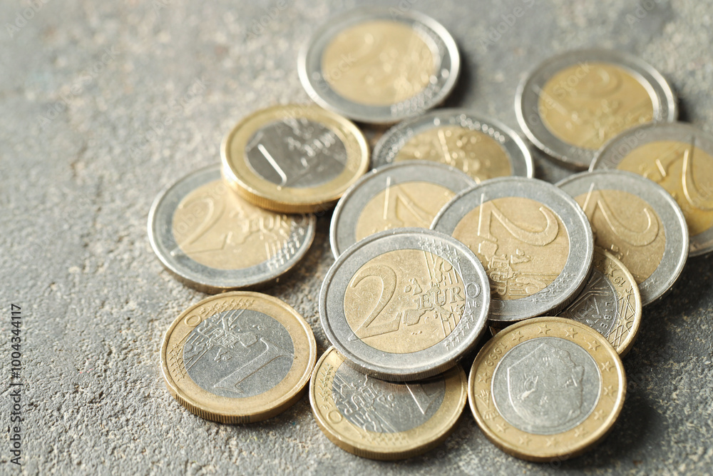 Many euro coins on grey table, closeup Many euro coins on grey table, closeup