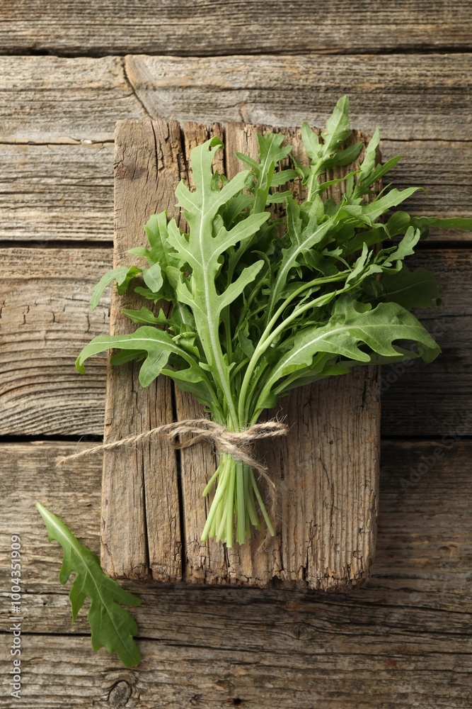 Bunch of fresh green arugula leaves on wooden table, top view Bunch of fresh green arugula leaves on wooden table, top view