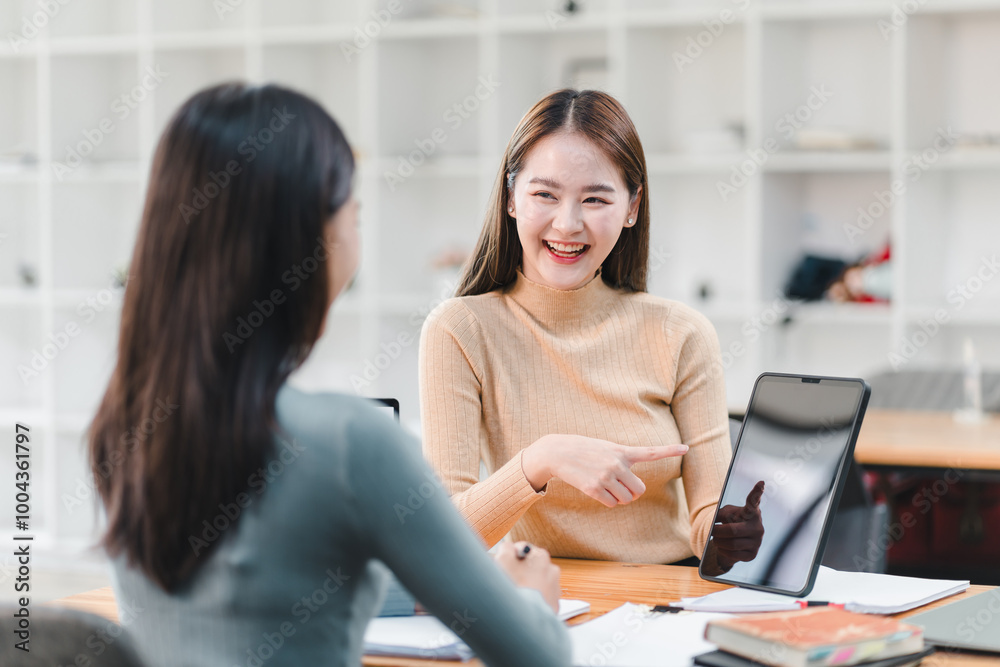 woman smiles and engages in friendly conversation with another woman in modern office setting, showcasing collaboration and teamwork. woman smiles and engages in friendly conversation with another woman in modern office setting, showcasing collaboration and teamwork.