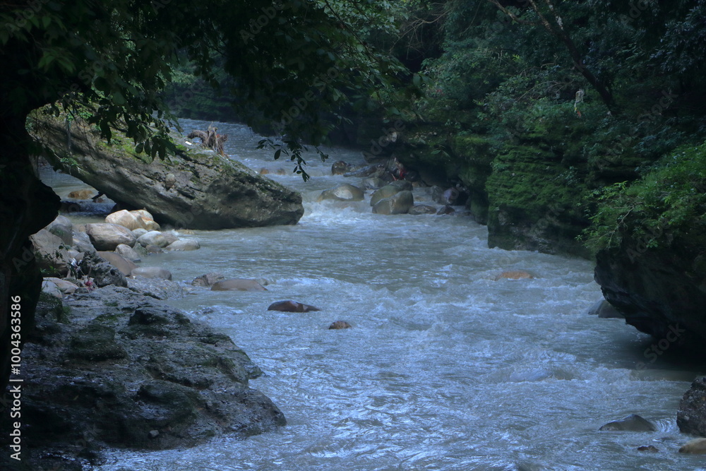Fototapeta premium Beautiful views of the flowing river at Tapkeshwar Temple in Dehradun from different angles.