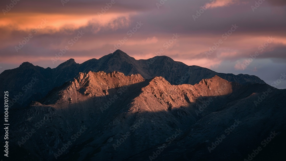 Fototapeta premium Sunrise Over Rugged Mountains with Warm Light