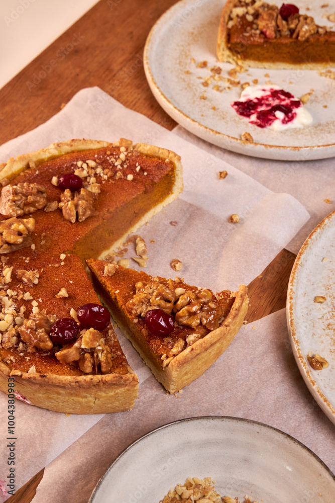 Fototapeta premium top view of a wooden table top with pumpkin pie and ceramic plates with pieces of pie on them