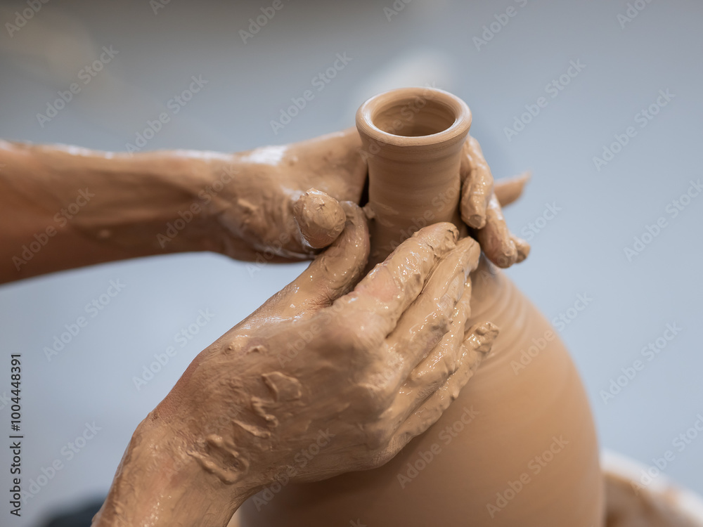Close-up of a potter's hands making a ceramic vase on a potter's wheel. Close-up of a potter's hands making a ceramic vase on a potter's wheel.