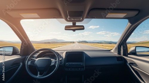 Interior of a modern car driving on a straight road under bright blue skies.