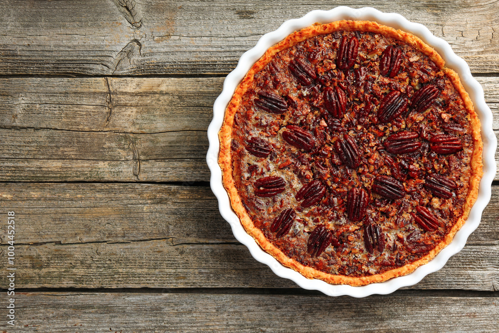 Delicious pecan pie in baking dish on wooden table, top view. Space for text Delicious pecan pie in baking dish on wooden table, top view. Space for text