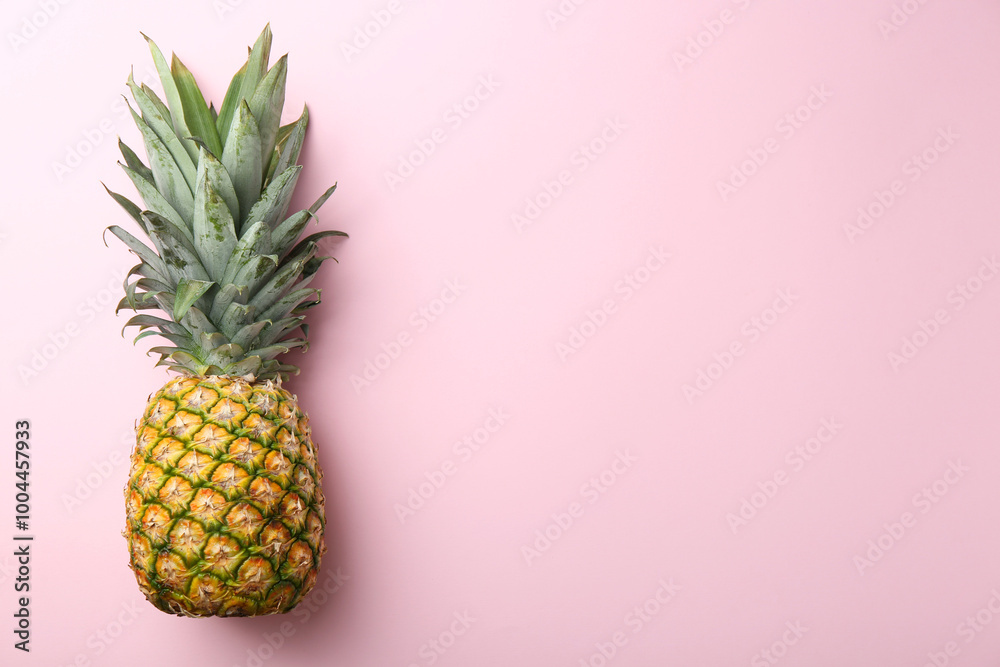 One fresh ripe pineapple on pink background, top view. Space for text One fresh ripe pineapple on pink background, top view. Space for text