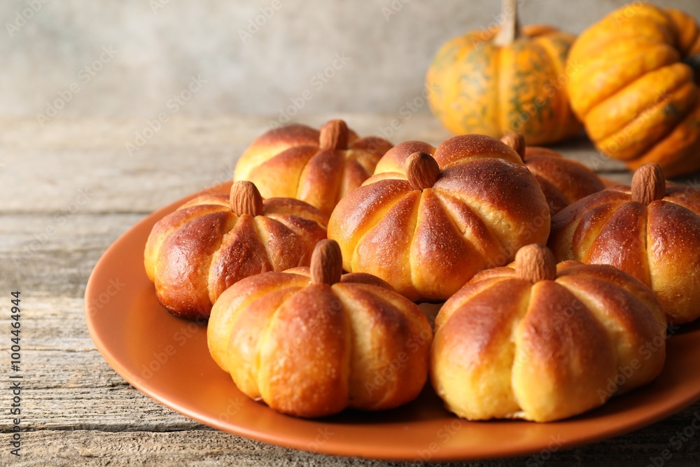 Tasty pumpkin shaped buns on wooden table, closeup Tasty pumpkin shaped buns on wooden table, closeup