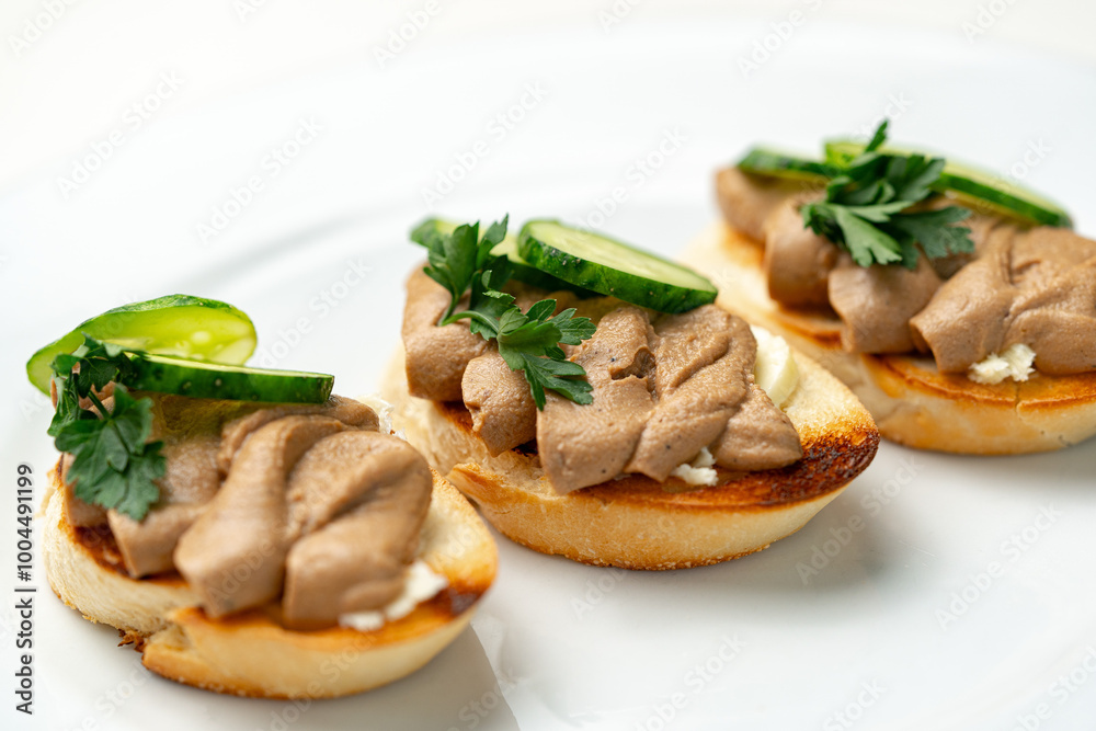 Savory canapes topped with creamy spread and cucumber slices served on toasted bread at a casual gathering Savory canapes topped with creamy spread and cucumber slices served on toasted bread at a casual gathering