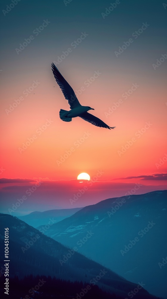 Fototapeta premium Silhouette of bird against a mountain sunset horizon.