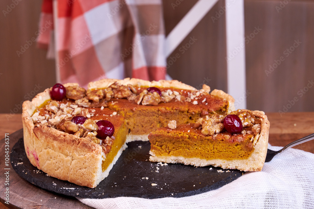 pumpkin pie on a wooden tray stands white on a table on the background of a white chair side view pumpkin pie on a wooden tray stands white on a table on the background of a white chair side view