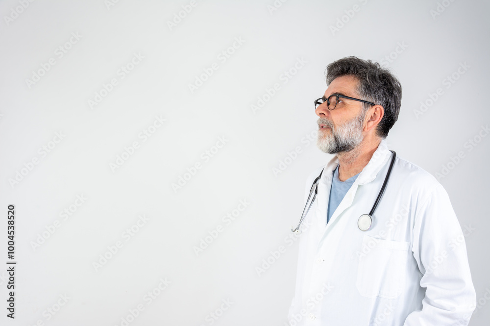 Happy looking male doctor. Confident male doctor in white uniform looking seriously at free space, copy space, important medical advertisement Happy looking male doctor. Confident male doctor in white uniform looking seriously at free space, copy space, important medical advertisement