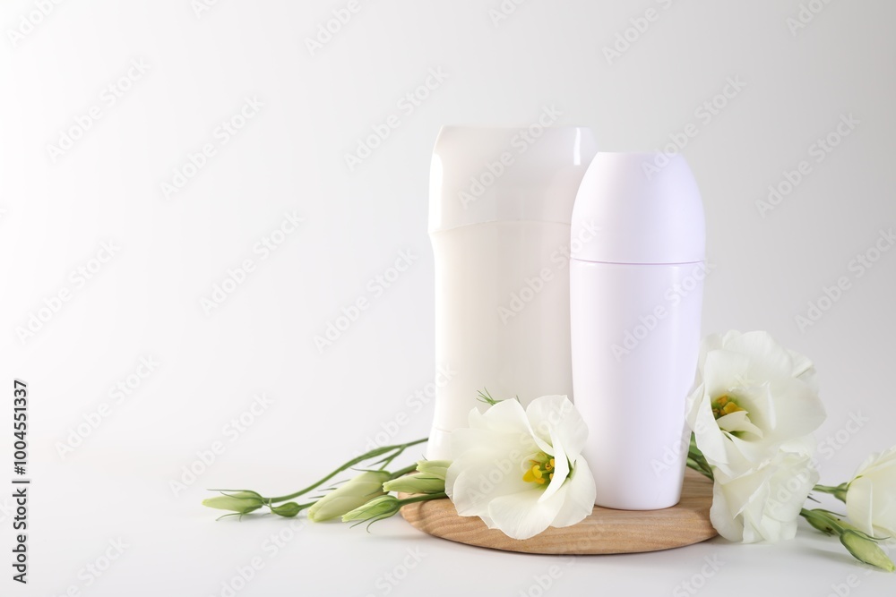 Different deodorants and beautiful eustoma flowers on white background, space for text