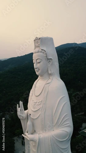 Lady Buddha at Sunset - Epic Aerial Done View of this incredible temple in the hills of Da Nang, Vietnam - Tourism Feature for Worldwide Tourists - Vertical Video