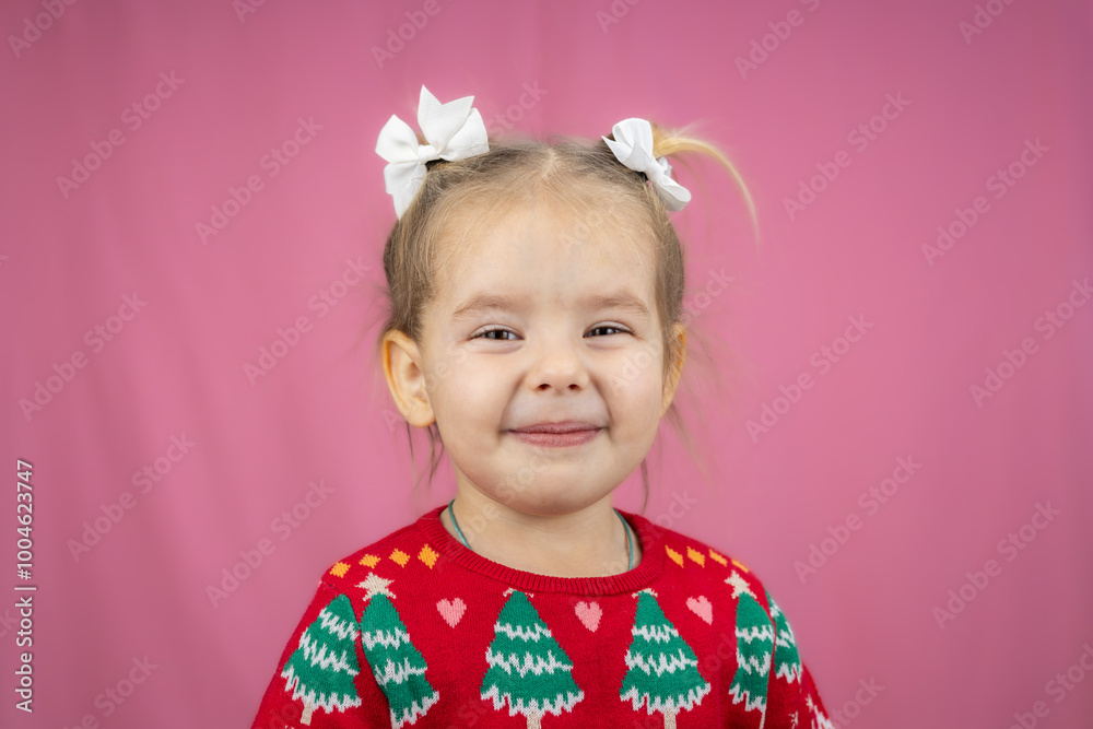 The child poses happily in a festive Christmas sweater, radiating joy and holiday spirit on a pink background. Perfect for greeting cards, banners and social media for Christmas and New Year. The child poses happily in a festive Christmas sweater, radiating joy and holiday spirit on a pink background. Perfect for greeting cards, banners and social media for Christmas and New Year.