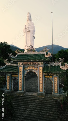 Lady Buddha at Sunset - Epic Aerial Done View of this incredible temple in the hills of Da Nang, Vietnam - Tourism Feature for Worldwide Tourists - Vertical Video