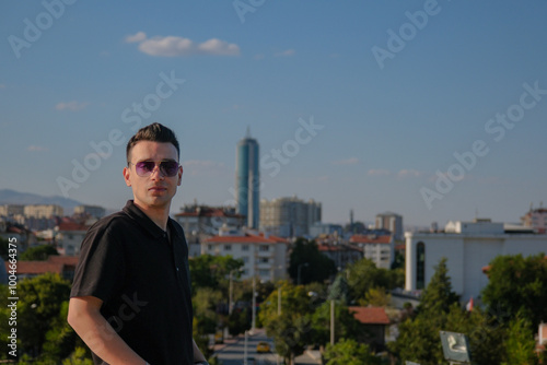 Portrait of young handsome man in front of city landscape photo