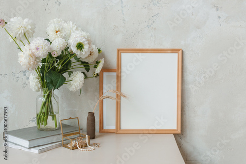 Billede på lærred Blank picture frames next to a vase with flowers and books, assorted accessories