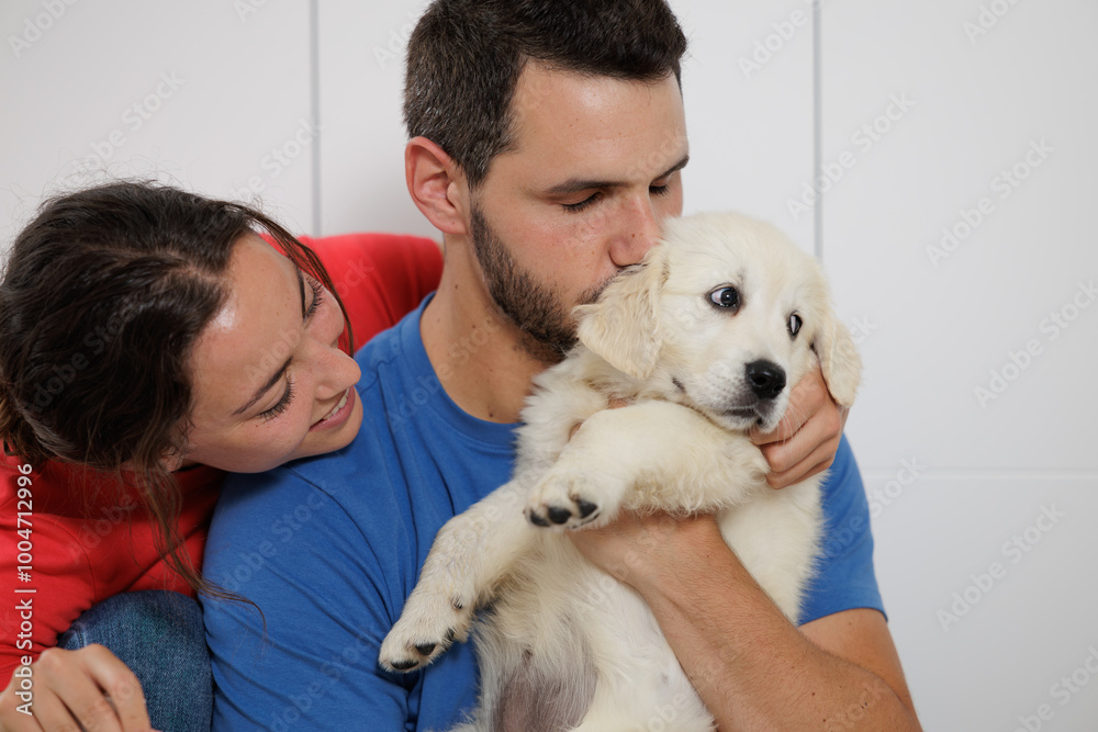 Portrait of a young couple with their golden retriever puppy. Family moments. Sharing time with loved ones. No to animal abandonment. Pets. The dog is man's best friend. Portrait of a young couple with their golden retriever puppy. Family moments. Sharing time with loved ones. No to animal abandonment. Pets. The dog is man's best friend.