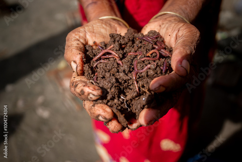 A rural woman trader displays vermicompost fertilizer in her palm.