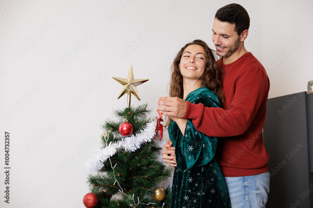 Young newlywed couple holding Christmas decorations in their hands to decorate their new home. Moments and experiences together that they will never forget. Young newlywed couple holding Christmas decorations in their hands to decorate their new home. Moments and experiences together that they will never forget.