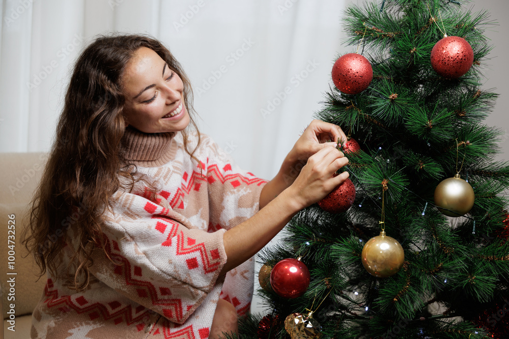 Young woman in Christmas dress decorating her house and putting up the Christmas tree. Christmas is a time of sharing with loved ones. Wishes, prosperity, new year. Shared happiness. Young woman in Christmas dress decorating her house and putting up the Christmas tree. Christmas is a time of sharing with loved ones. Wishes, prosperity, new year. Shared happiness.