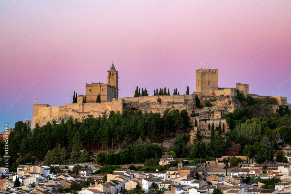 La Mota Fortress in Alcalá la Real, Jaén, Andalusia, Spain, with pink sunrise light and the town below La Mota Fortress in Alcalá la Real, Jaén, Andalusia, Spain, with pink sunrise light and the town below
