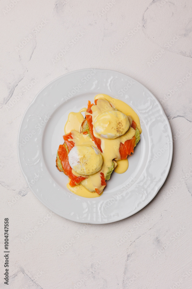 A hearty brunch of toast, avocado, salmon and poached eggs with cheese sauce. A hearty brunch of toast, avocado, salmon and poached eggs with cheese sauce.