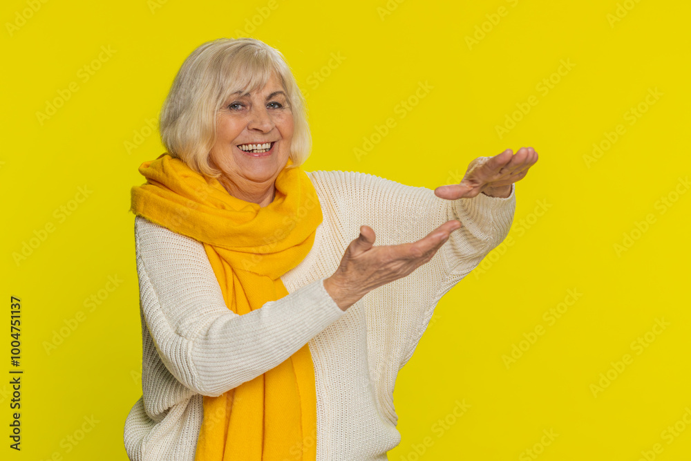 Senior woman showing wasting throwing sharing money around, more tips big profit winning lottery jackpot, successful shopping payment purchase cashback. Elderly mature grandmother on yellow background