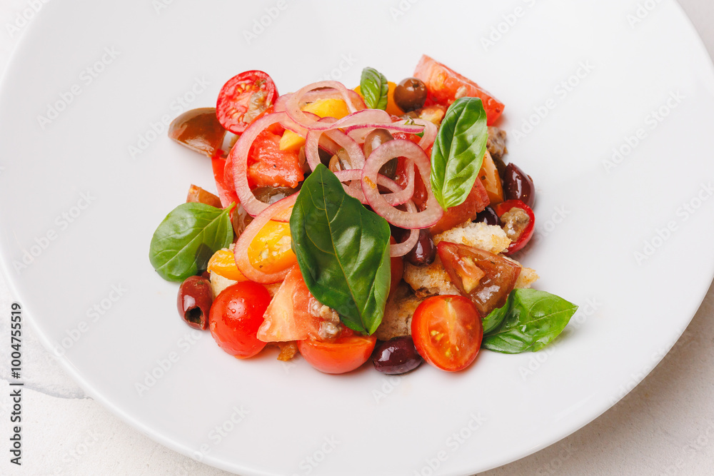Appetizing salad with tomatoes, onions, olives and crispy croutons in a large white plate. Appetizing salad with tomatoes, onions, olives and crispy croutons in a large white plate.