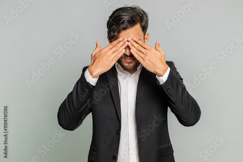 Don't want to look at this, awful. Afraid shocked Indian businessman closing eyes with hand showing stop gesture, confused shy scared reject to watch. Male Arabian man guy isolated on gray background