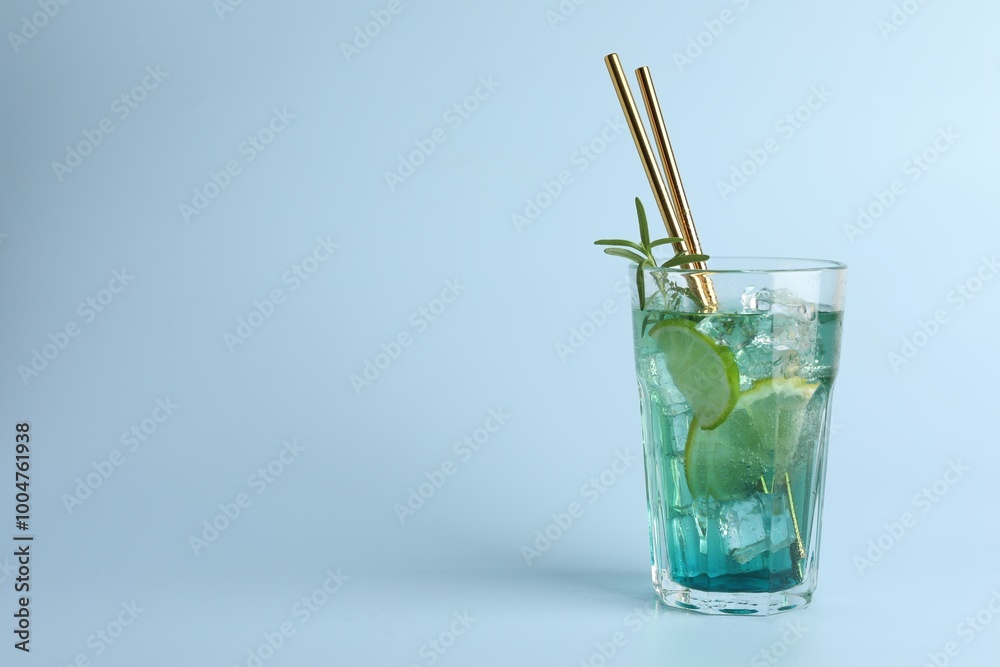 Tasty refreshing drink with straws in glass on light blue background, space for text Tasty refreshing drink with straws in glass on light blue background, space for text