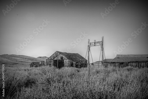 Weathered wooden structures stand abandoned in Bodie Ghost Town, California. Once a bustling Gold Rush settlement, now a preserved slice of Wild West history set against a desolate desert landscape.