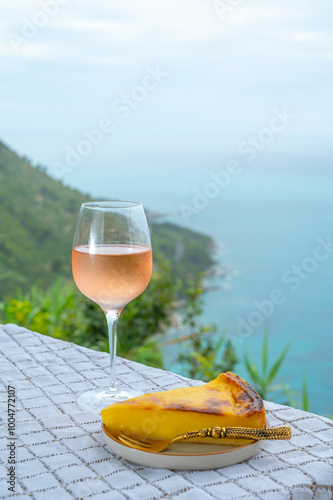 Summer time in Provence, glass of cold rose wine and flan dessert with blue sea view on background, French Riviera near Menton, south of France photo