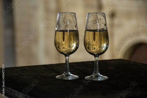 Sherry wine glasses with fino and old church on background at night in Jerez de la Frontera, wine glasses outdoor, cityview, Andalusia, Spain