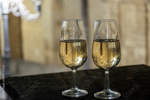 Sherry wine glasses with fino and old church on background at night in Jerez de la Frontera, wine glasses outdoor, cityview, Andalusia, Spain