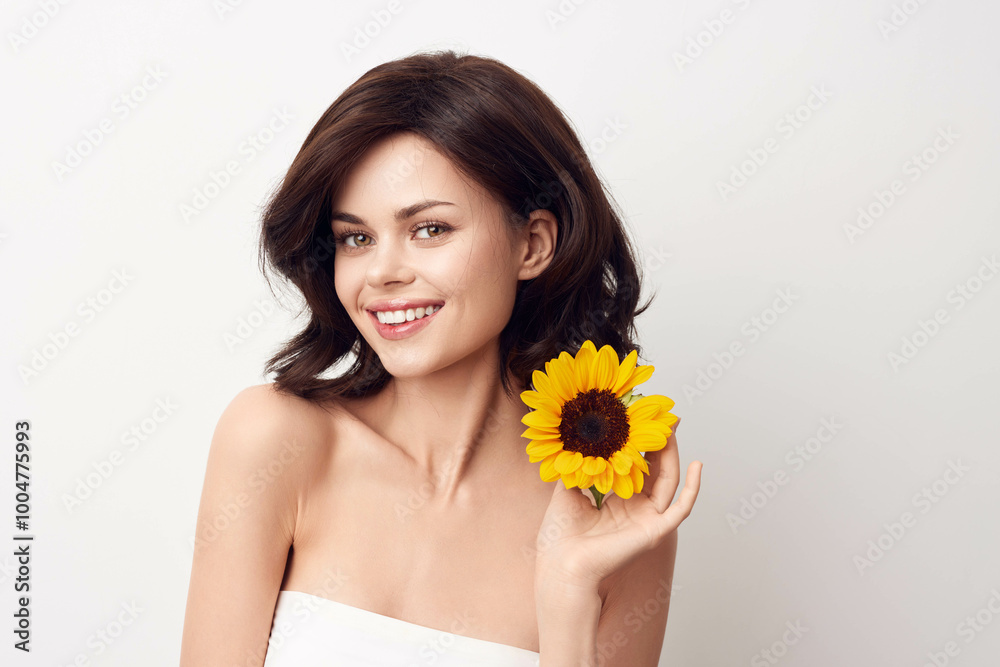 Beautiful young woman holding a sunflower on a white background Beautiful young woman holding a sunflower on a white background