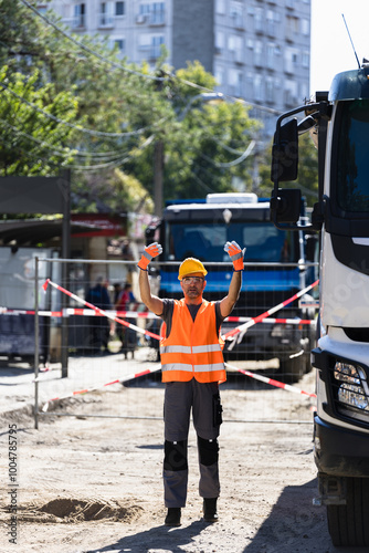 Construction worker directing traffic at a busy urban site during daytime in a bustling neighborhood