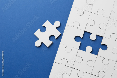 White puzzle pieces on blue background, top view photo