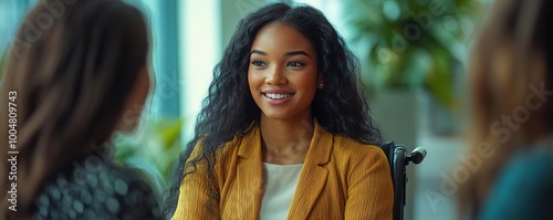 A woman smiles engagingly during a conversation in a modern office setting, exuding confidence and warmth. photo