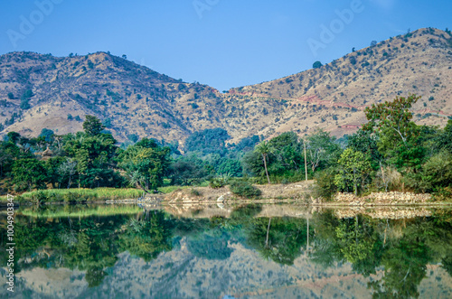 Scenic view of a freshwater rivulet winding through rocky terrain on way from Udaipur to Kumbalgarh Fort, Rajasthan, India photo