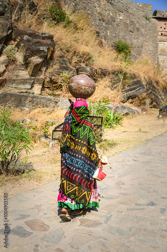 A village woman carrying pot of water on her head