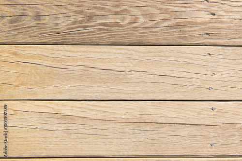 A clean wooden deck with light traces of sand. The natural wood grain and soft sand create a calm, earthy aesthetic, ideal for use as a background or texture.