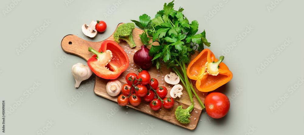 Fresh vegetables with cutting board on grey background Fresh vegetables with cutting board on grey background