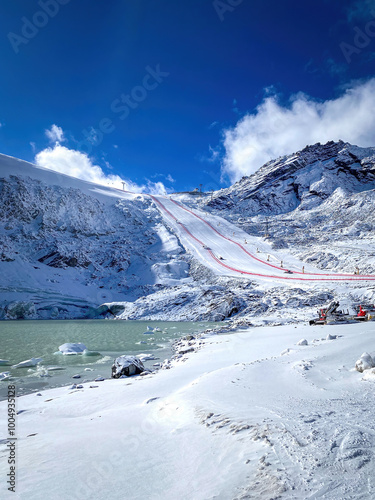 Soelden Rettenbachferner glacier, Austria with World Cup Giant Slalom ski race slope and lake infront against cloudy sky photo