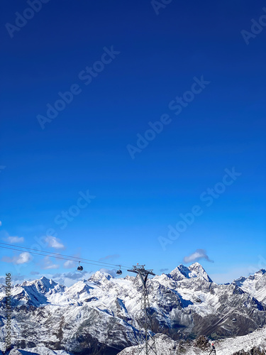 Cable Car in Oetztal Alps and Soelden ski region infront of snowcovered mountains against blue sky photo