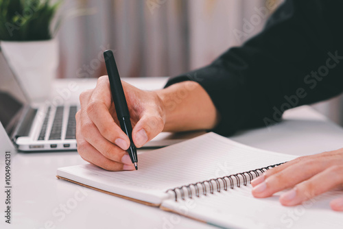 Male hand taking notes on the notepad. businessman working at work table, checklist writing planning investigate enthusiastic concept. focus on man hand holding pen, putting signature at official pape