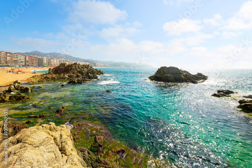 View from a hilltop trail near Cala Banys beach of the Platja de Lloret de Mar, the wide sandy beach at the Costa Brava town of Lloret de Mar, Spain.	 photo