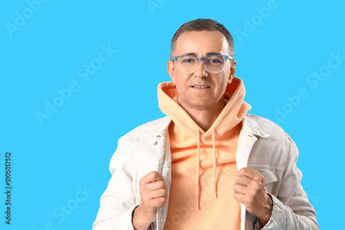 Mature man in eyeglasses on blue background